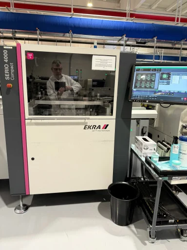 Hersteller: Ekra Modell: Serio 4000 Laborgerät in einer modernen Fertigungsumgebung mit Bedienfeld und Arbeitsstation.